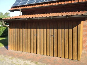 A wooden garage with a tiled roof and a brick wall. - Suite Anna with terrace 25 u (SA) - Usedom Suites 25***, beach 100 m (Karlshagen)