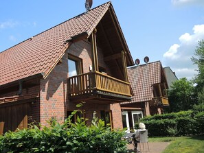 A two-story house with a sloped roof, a wooden balcony, and satellite dishes on the roof. - Suite Anna with terrace 25 u (SA) - Usedom Suites 25***, beach 100 m (Karlshagen)