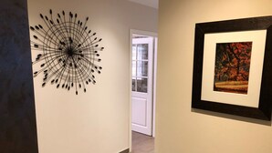 Ein Flur mit moderner Kunstinstallation und einem gerahmten Landschaftsbild.