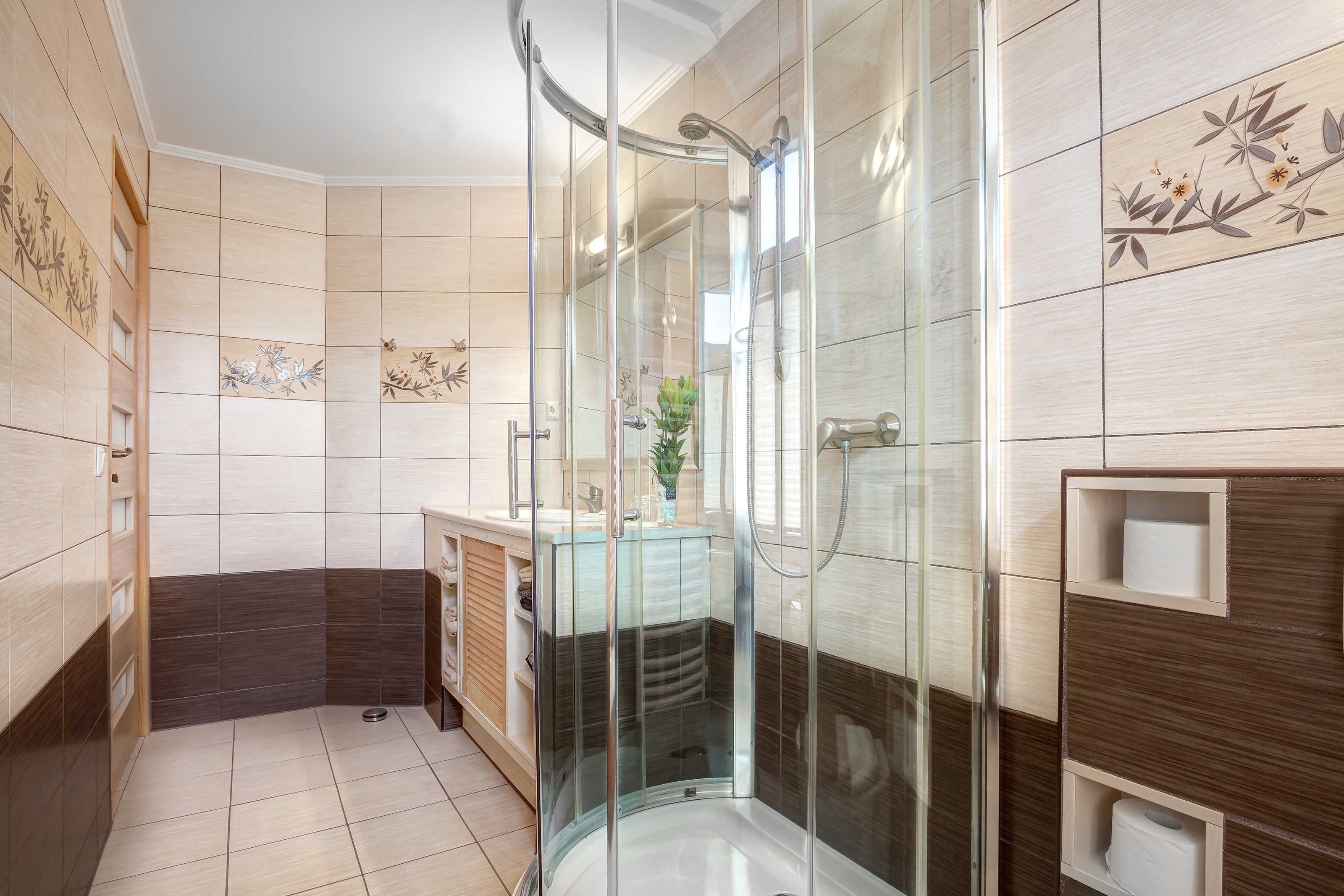 Une salle de bain moderne avec une douche à parois de verre, un meuble-lavabo avec un miroir et des toilettes.