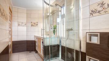 Une salle de bain moderne avec une douche à parois de verre, un meuble-lavabo avec un miroir et des toilettes.