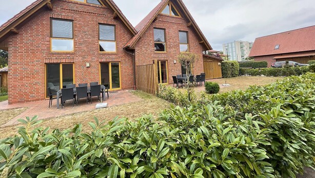 A two-story brick house with a patio area featuring a table and chairs. - House 13 Ute (SA) - Usedom Suites House Ute and Baigle***, beach 100 m (Karlshagen)