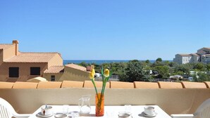 Ein Tisch für zwei Personen mit Blick auf das Meer und Gebäude im Hintergrund.
