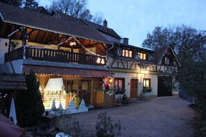 Een klassiek chalet met balkon, houten gevel en kerstdecoraties.