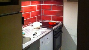 A compact kitchen with a microwave, stove, and oven. - COURCHEVEL 1650, stand. apartment sleeps 8, 100 m gondola, covered parking. (Courchevel Moriond)