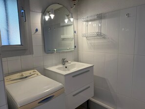A bathroom with a white sink, a mirror above it, a toilet, and a window. - Studio in Banyuls-sur-Mer, terrace close to beaches (Banyuls-sur-Mer)