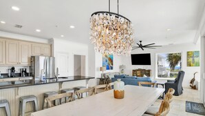 A spacious kitchen with modern appliances, a dining area with a large table and wooden chairs, and a ceiling fan. - "Romar House at Beachside"Great Location-Private Heated Pool"ALVacationRentals" (Orange Beach)