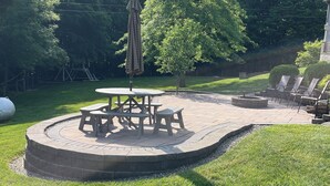 A circular patio area with a fire pit, picnic table, and chairs. - Sunrise Apt. - Peaceful Country Setting- Reasonable Distance to Hocking Hills  (Amanda)