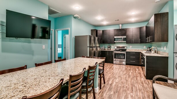 A modern kitchen with dark cabinets, a granite countertop, and stainless steel appliances. - 8 Private Bedrooms+Bathrooms! HUGE POOL+KITCHEN+PRIVATE RETREAT By the Beach!!! (Myrtle Beach)