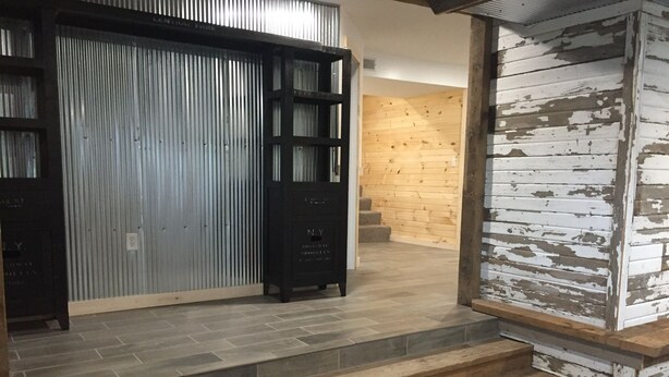 A staircase leading to a wooden interior with a metal door and a white-painted wall.