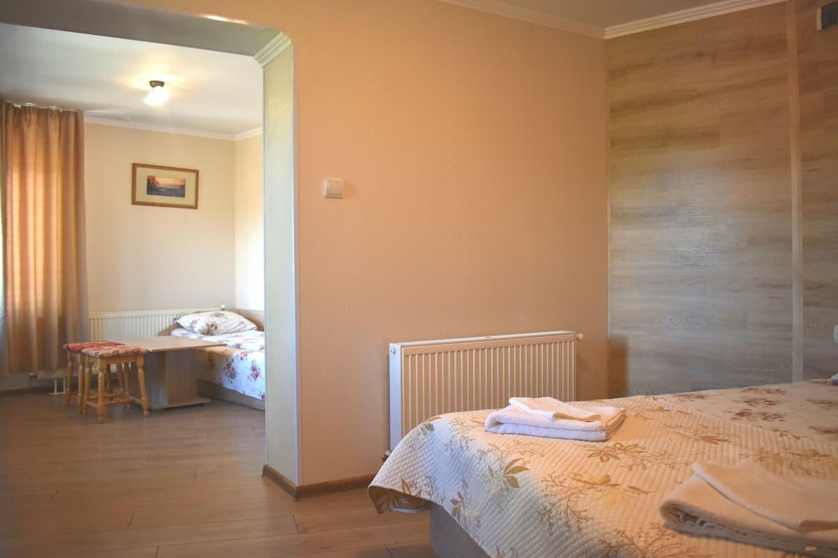 A hotel room with a bed, a desk, and a chair.