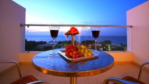 A balcony with a table set for two, featuring a fruit platter and two glasses of red wine, overlooking a scenic view. - Club Marmara Doreta Beach Resort & Spa All Inclusive (Rhodes)