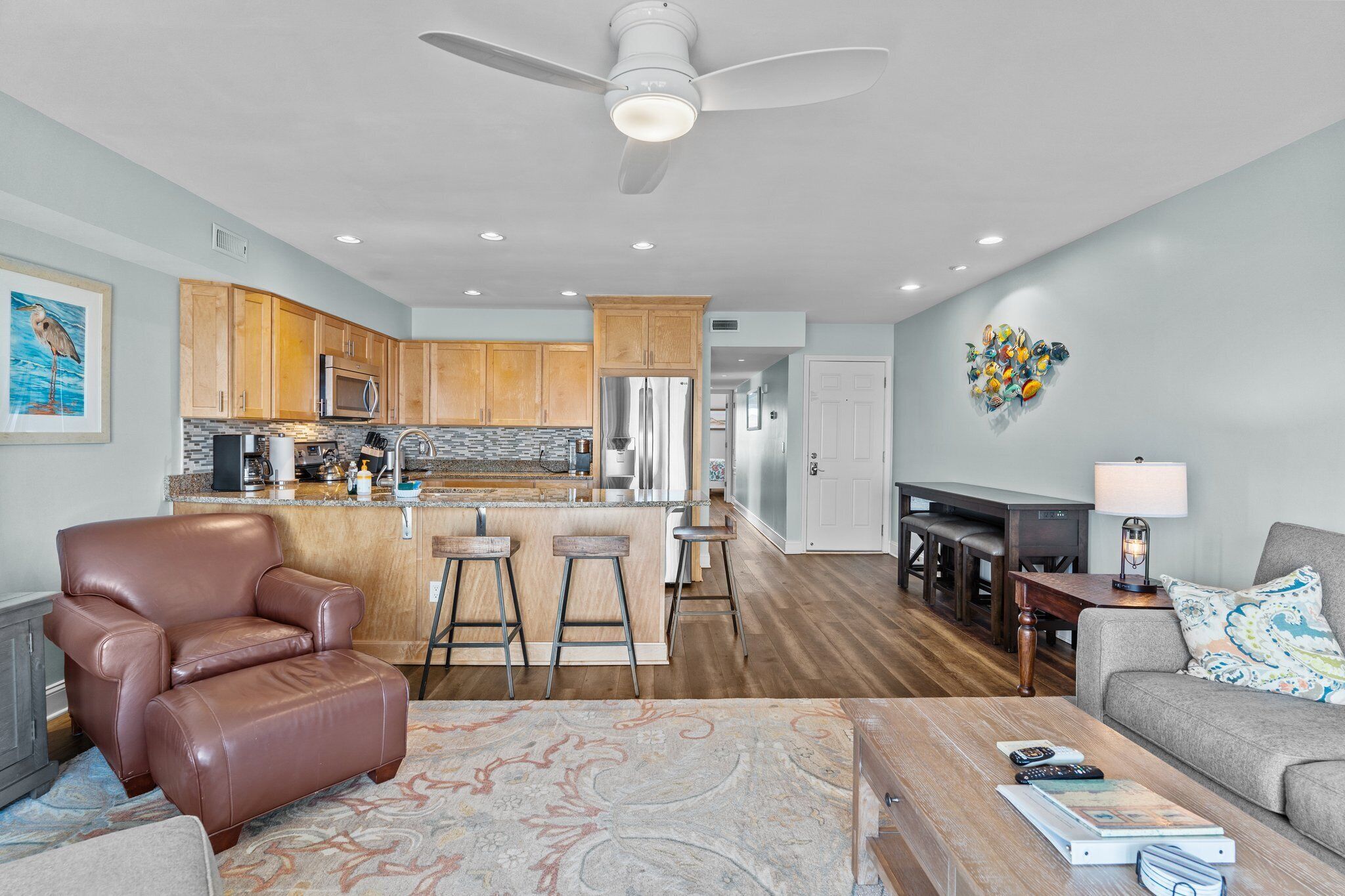 A modern kitchen with wooden cabinets, stainless steel appliances, and a bar area.