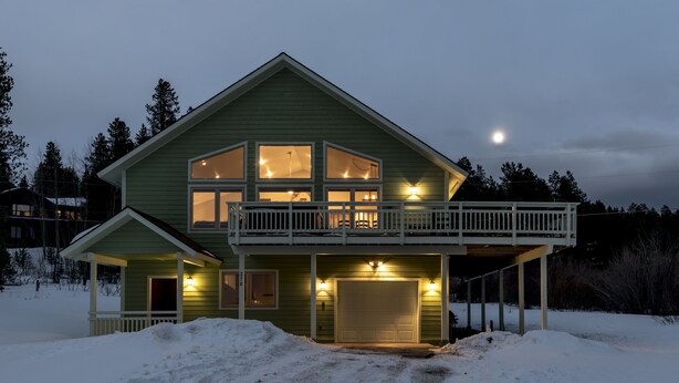 A two-story house with a balcony, a garage, and a snow-covered yard. - Breathtaking Mountain Sunsets! 6BR, 3 King Beds, Hot Tub, Shuttle, Sleeps 16+ (Fraser)