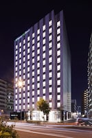 A high-rise hotel with illuminated windows and a prominent entrance.