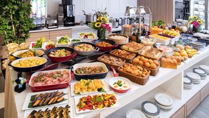 Un bufé con diversas opciones de comida y una estación de café.