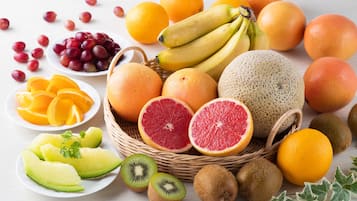 Une variété de fruits, notamment des raisins, des bananes, des oranges et des kiwis.