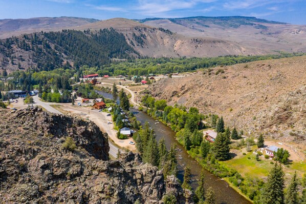 A river flowing through a valley with buildings and trees. - Adobe House on Taylor River | 3 Bedroom | River Access | Gas Grill | Yard (Almont)