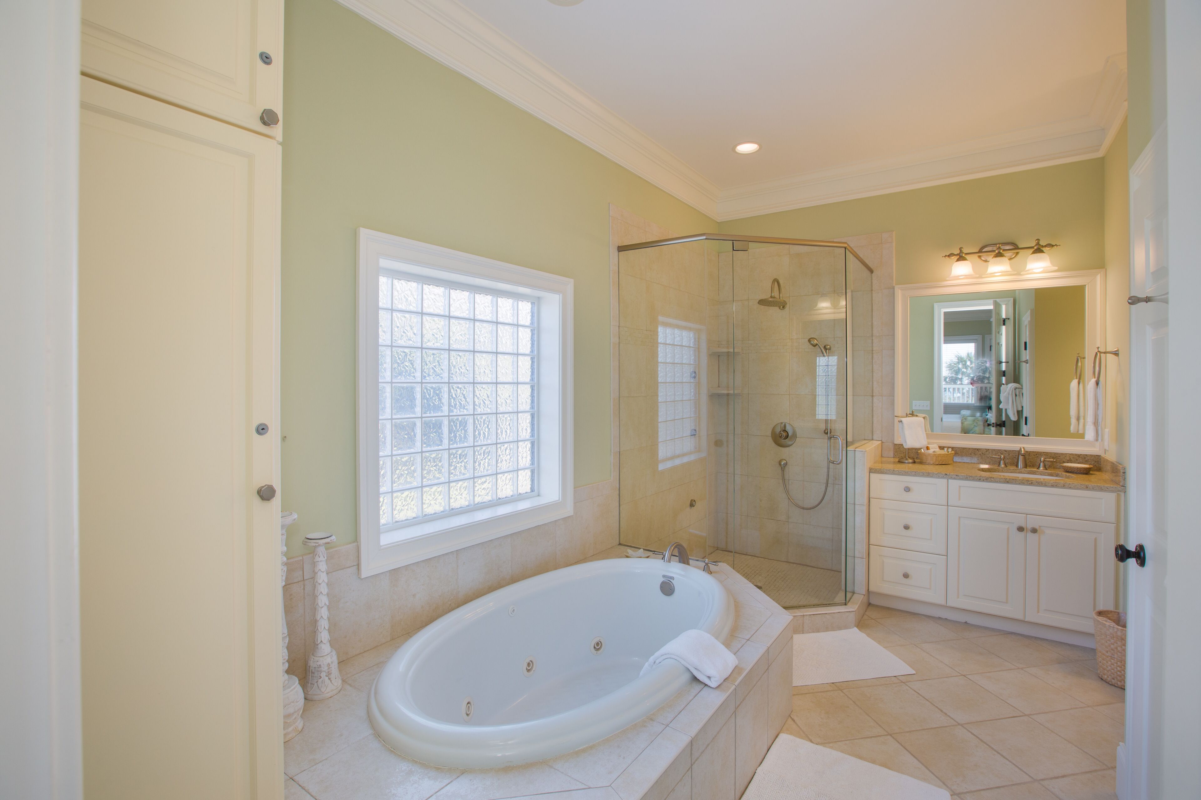 A spacious bathroom with a large bathtub, a walk-in shower, and a vanity with a mirror.