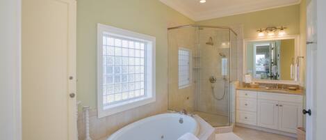 A spacious bathroom with a large bathtub, a walk-in shower, and a vanity with a mirror.