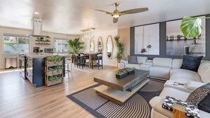 A spacious living area with a modern kitchen, a dining area, and a seating area with a sofa and coffee table.