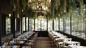 A restaurant with long tables, hanging greenery, and a chandelier. - Karuizawa Hotel Longing House (Karuizawa)