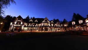 A large, illuminated building with a traditional architectural style, featuring multiple levels and a prominent entrance. - Karuizawa Hotel Longing House (Karuizawa)