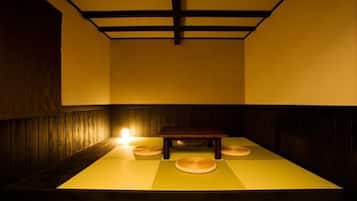 Um quarto japonês tradicional com tatames, uma mesa baixa e almofadas.