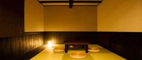 Una habitación japonesa tradicional con suelo de tatami, una mesa baja y cojines.