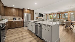 Une cuisine moderne avec des armoires en bois, des appareils électroménagers en acier inoxydable et un grand îlot central.