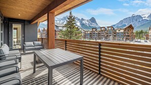 Un balcon donnant sur des maisons de montagne et doté d’une balustrade en bois.
