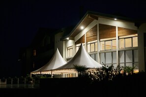 A modern building with a large, illuminated tent structure in front. - Hostellerie Du Chambellan (Pontpierre)