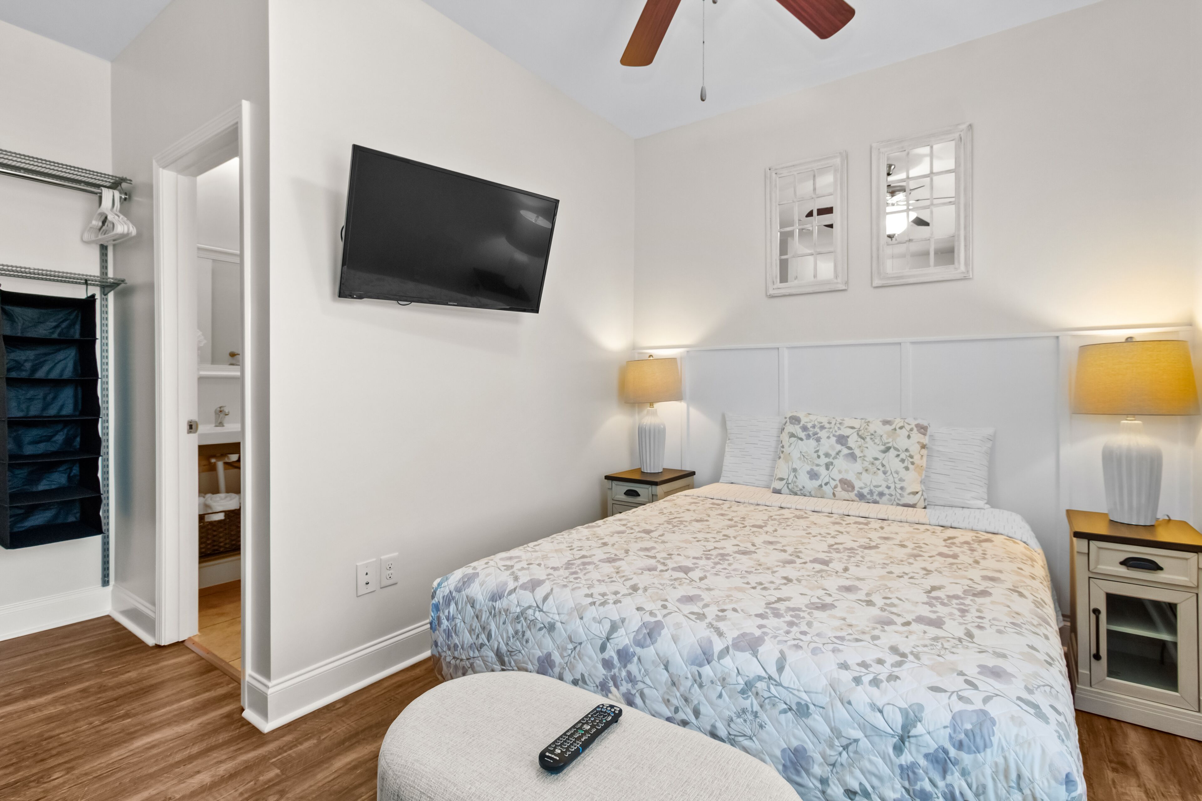 A bedroom with a bed, bedside lamps, a TV, and a wardrobe.