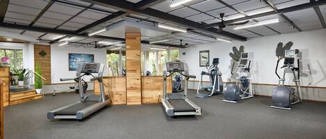 A gym with treadmills, elliptical machines, and stationary bikes.