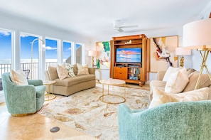 Relax in this ocean-view living room with a sofa, armchair, and flat-screen TV.