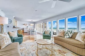 Relax in a spacious living area with ocean views, featuring a variety of seating options and a modern design.