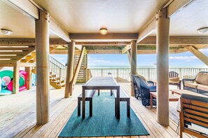 Relax on the deck with a central table and comfortable seating, overlooking a serene body of water.