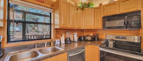 A kitchen with wooden cabinets, a sink, a dishwasher, a stove, and a microwave.