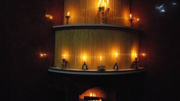 A fireplace with multiple candles and a candelabra.