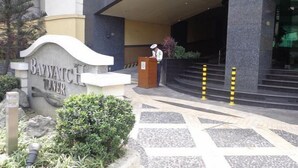 The entrance to the Bavwatch Tower hotel with a podium and a person standing behind it. - Baywatch Tower (Manila)