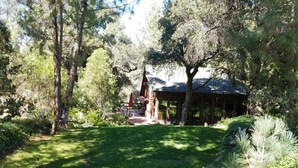 A serene garden with a gazebo, surrounded by mature trees and a well-maintained lawn. - Charming log cabin surrounded by the hills of the Cleveland National Forest (Pine Valley)