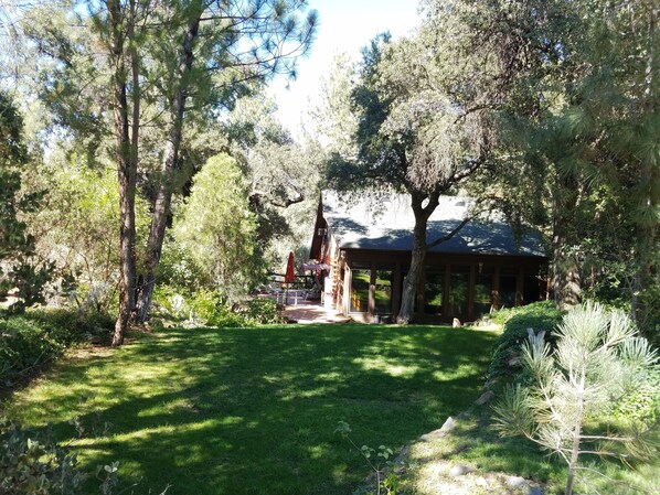 A serene garden with a gazebo, surrounded by mature trees and a well-maintained lawn. - Charming log cabin surrounded by the hills of the Cleveland National Forest (Pine Valley)
