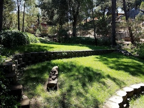 Stroll through the serene garden, surrounded by lush greenery and a charming stone structure.