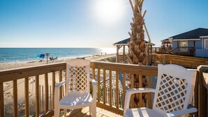 A wooden deck with white chairs overlooking a beach and ocean. - A Villa Roja: Oceanfront Home with Incredible Views, Deck, Open Concept (Oak Island)