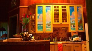 Une cuisine avec des meubles en bois, un plan de travail en marbre et un évier.