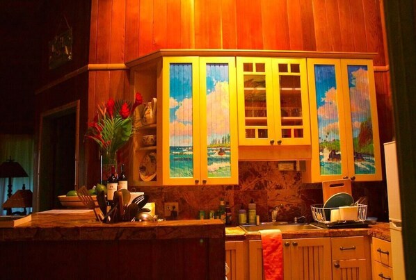 A kitchen with wooden cabinets, a marble countertop, and a sink.