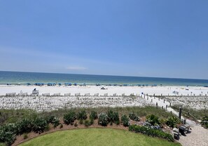 Une plage de sable blanc, un ciel bleu azur et une vue sur l’océan.