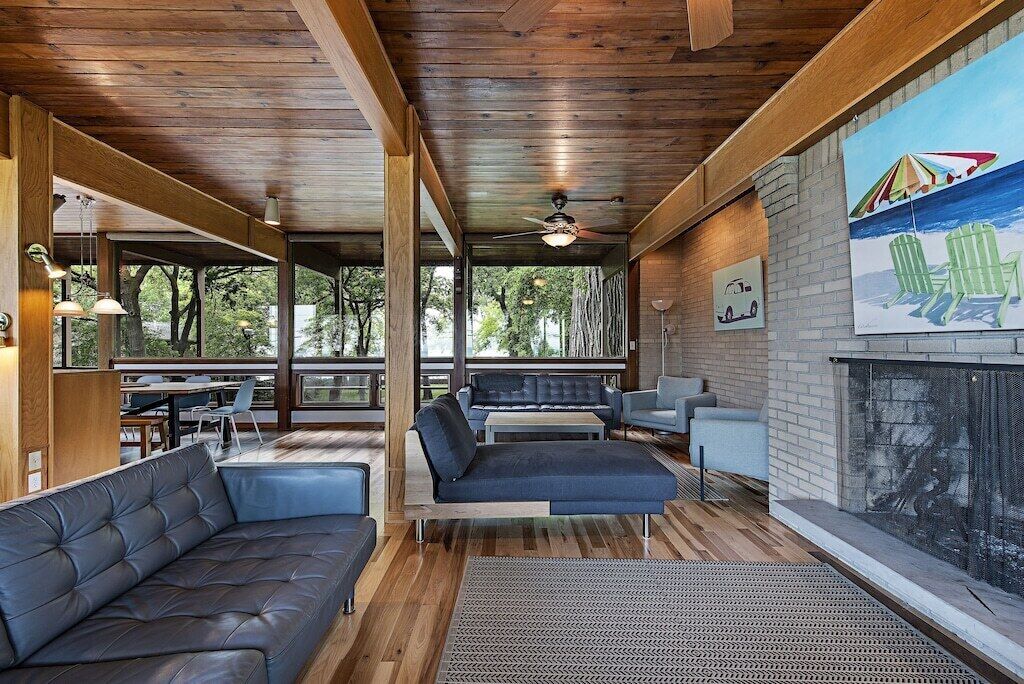 A modern interior with a wooden ceiling, a fireplace, and a view of the outdoors.