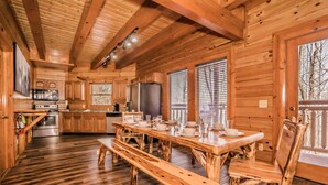 Eine Holzhütte mit Küche, Essbereich und großen Fenstern.