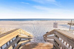 A wooden boardwalk leading to a beach with a sign indicating 'Leave Only Trash'.